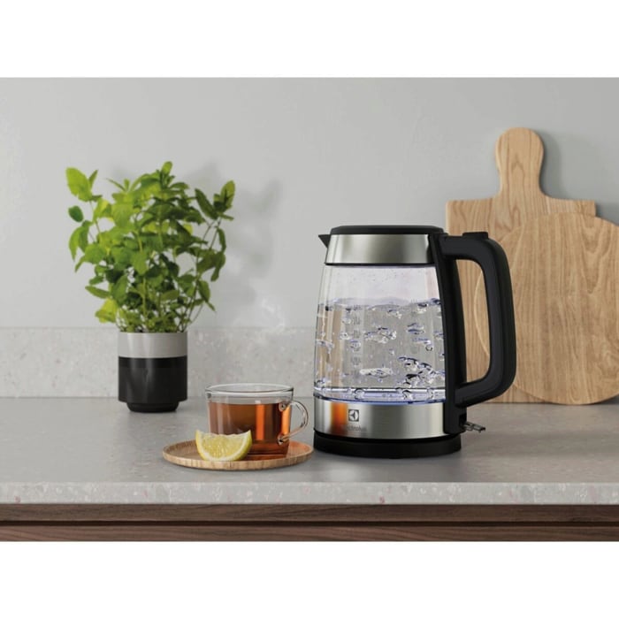 A photo of a glass kettle Create 4 next to a glass of tea