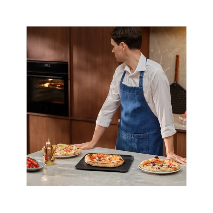 Person with the pizza expert oven and cast iron tray with Neapolitan pizzas 