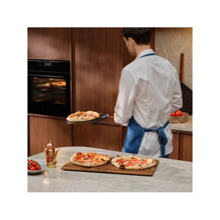 Person with the pizza expert oven and pizza peel tray with Neapolitan pizzas 