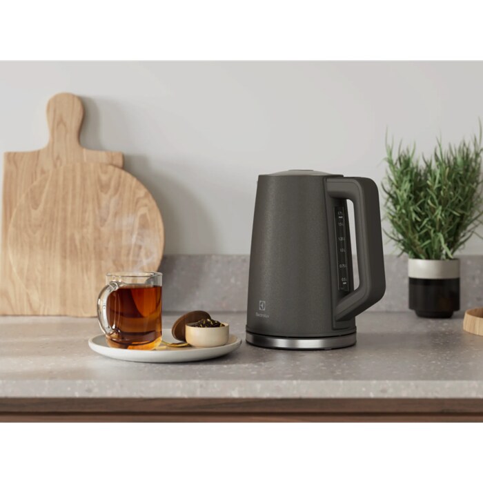 A photo of a antracite kettle Create 5 next to a glass of tea