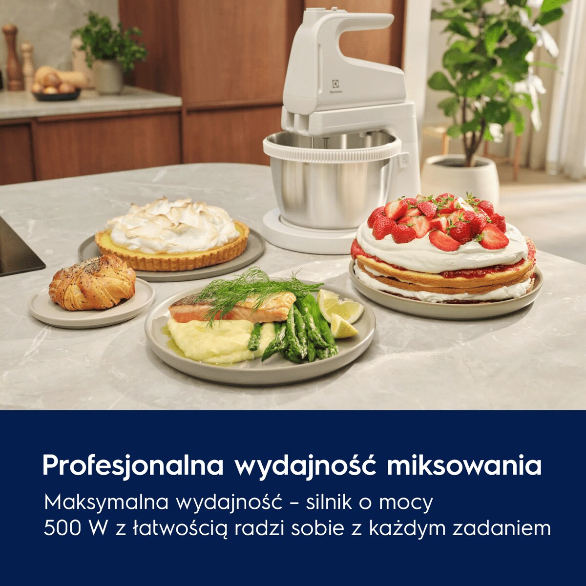 A white mixer with a bowl next to various delicious looking dishes on a table