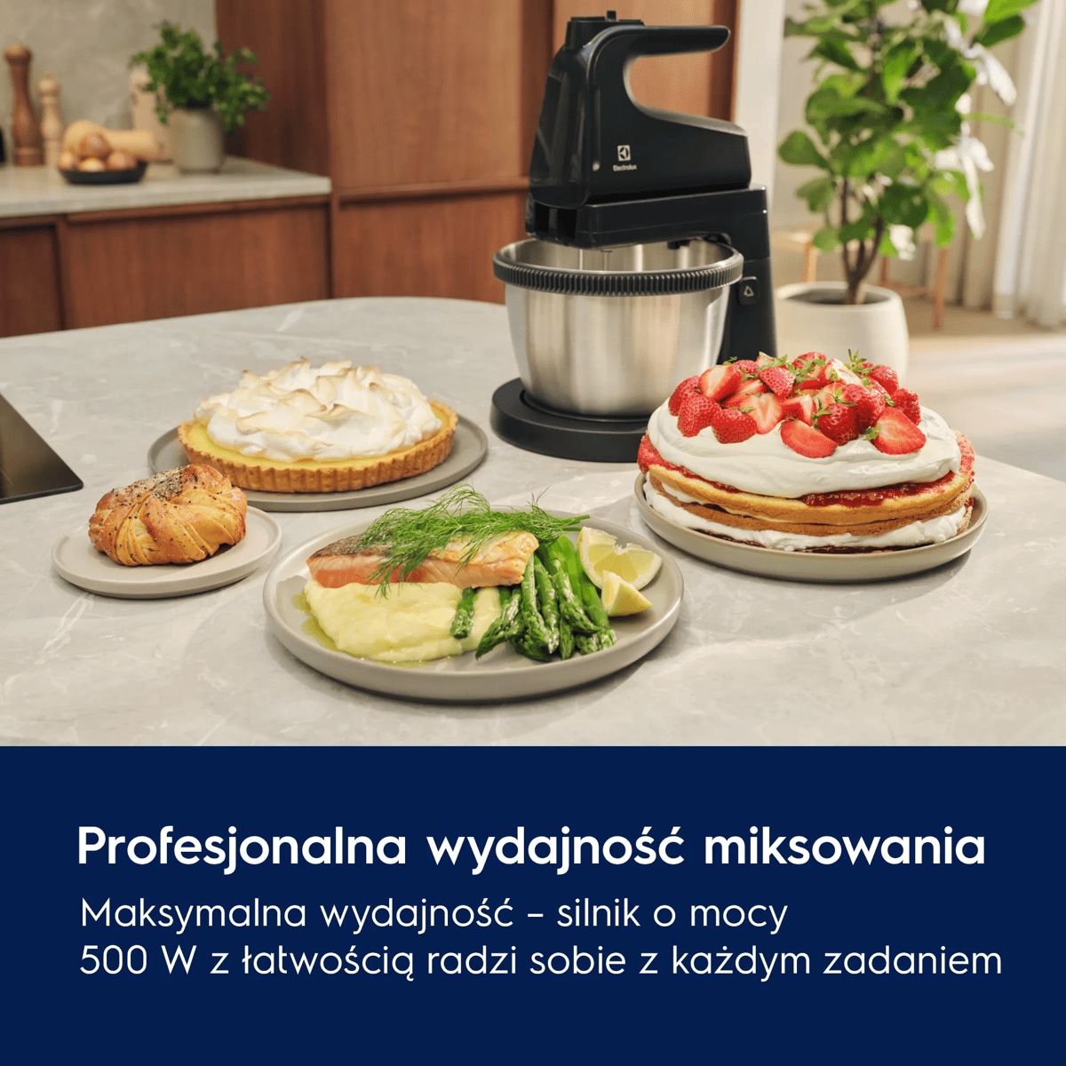 A black mixer with a bowl next to various delicious looking dishes on a table