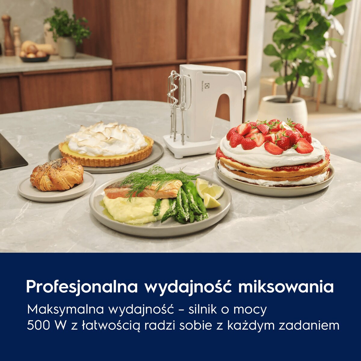 A white hand mixer next to various delicious looking dishes on a table