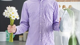 Mężczyzna w koszuli, która jest w połowie pognieciona, a w połowie gładka, aby zilustrować zalety technologii SteamCare