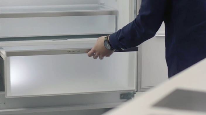 Otwiera szufladę chłodziarki