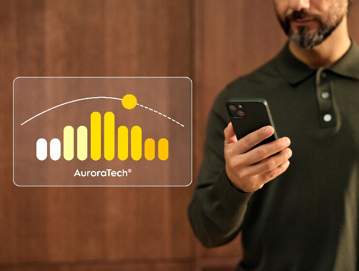 Mężczyzna sterujący funkcjami okapu kuchennego za pomocą telefonu.