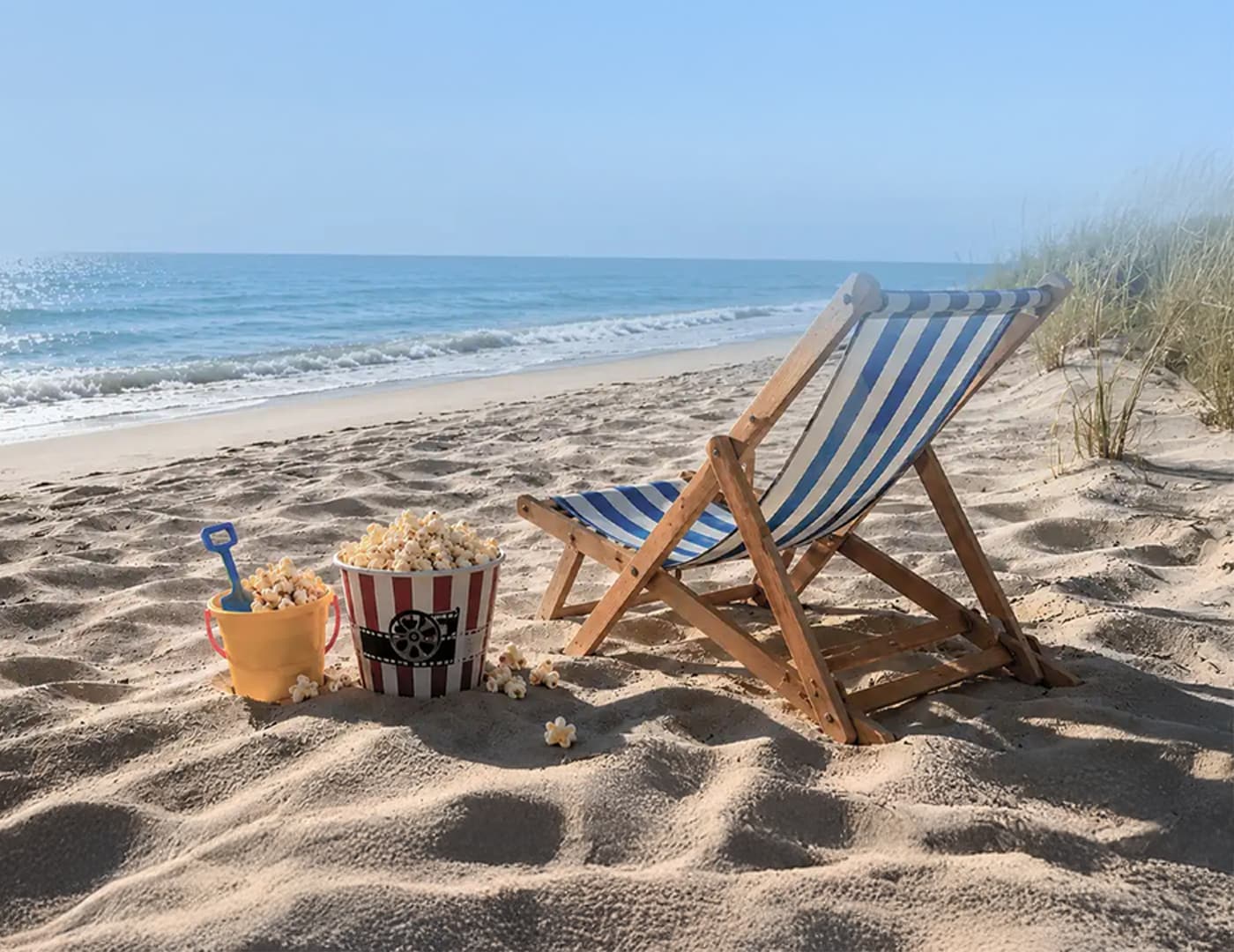 Leżak obok kubełka z popcornem na słonecznej plaży