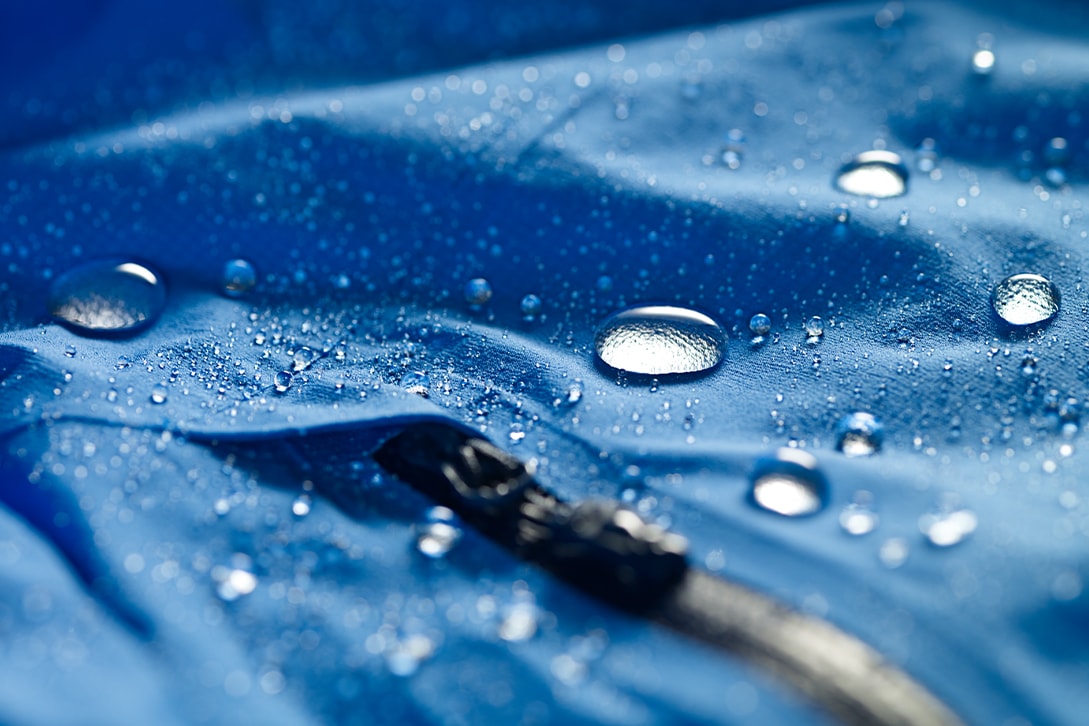 Zdjęcie kropel na niebieskiej kurtce o właściwościach wodoodpornych