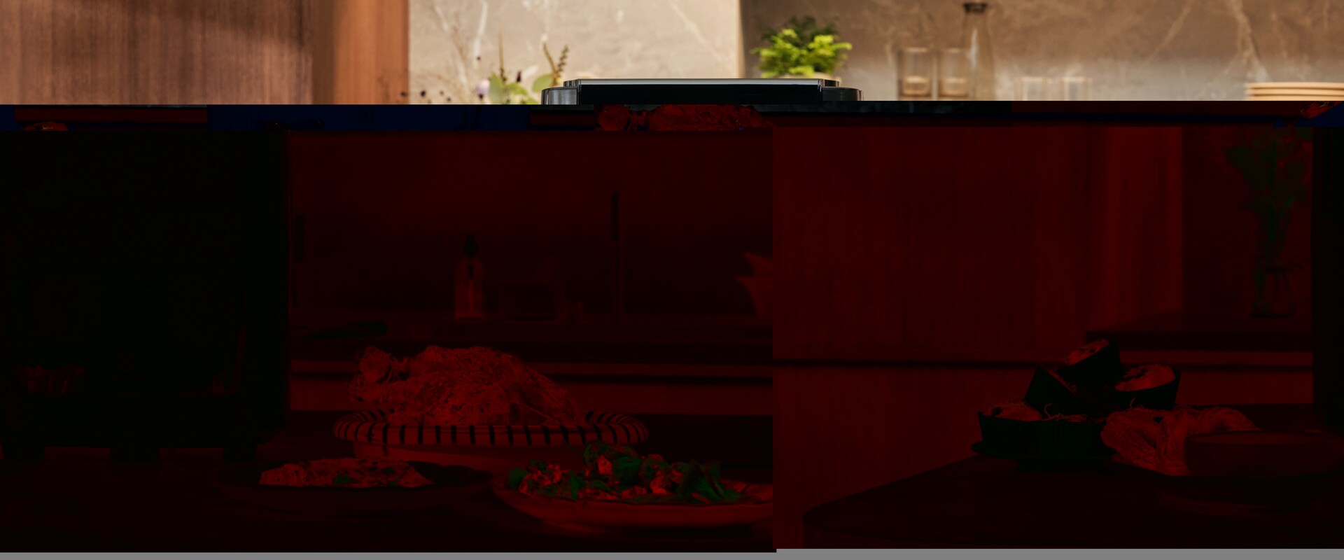 Zdjęcie air fryera Electrolux na kuchennym blacie obok pysznie wyglądających potraw