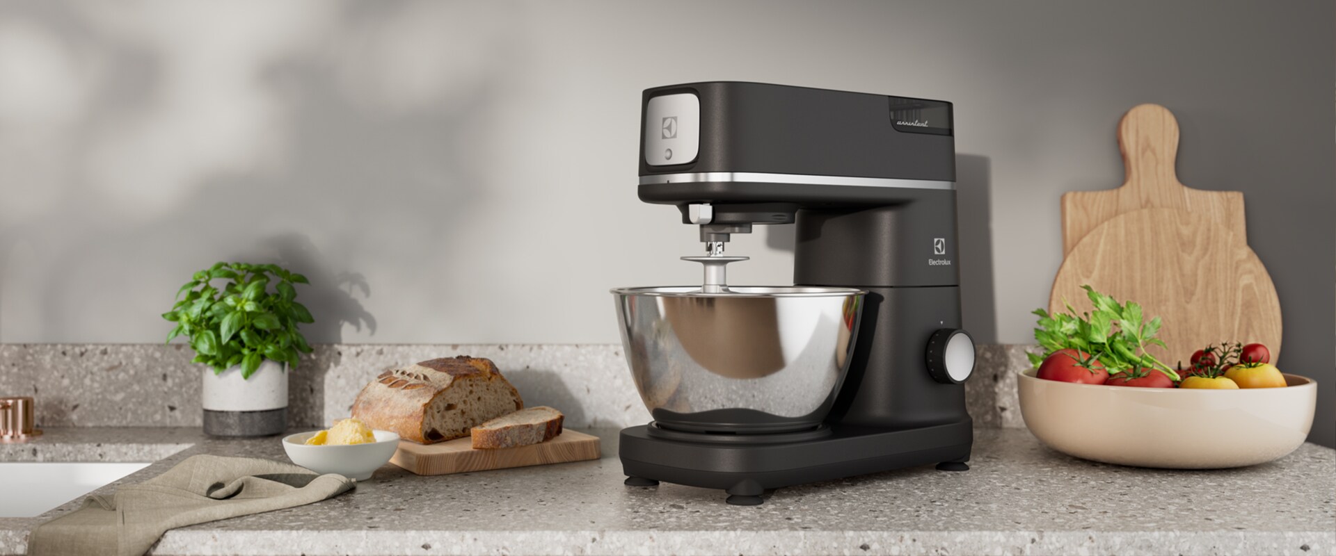 Zdjęcie czarnego robota kuchennego Electrolux na kuchennym blacie obok miski warzyw