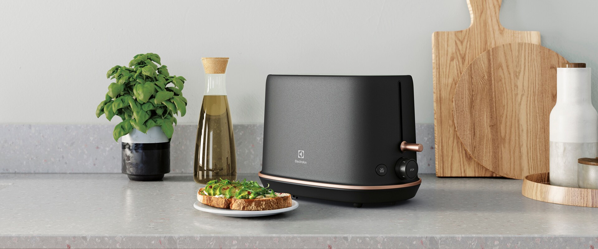 Zdjęcie tostera Electrolux Explore 7 na kuchennym blacie obok talerzyka, na którym leżą dwa upieczone tosty